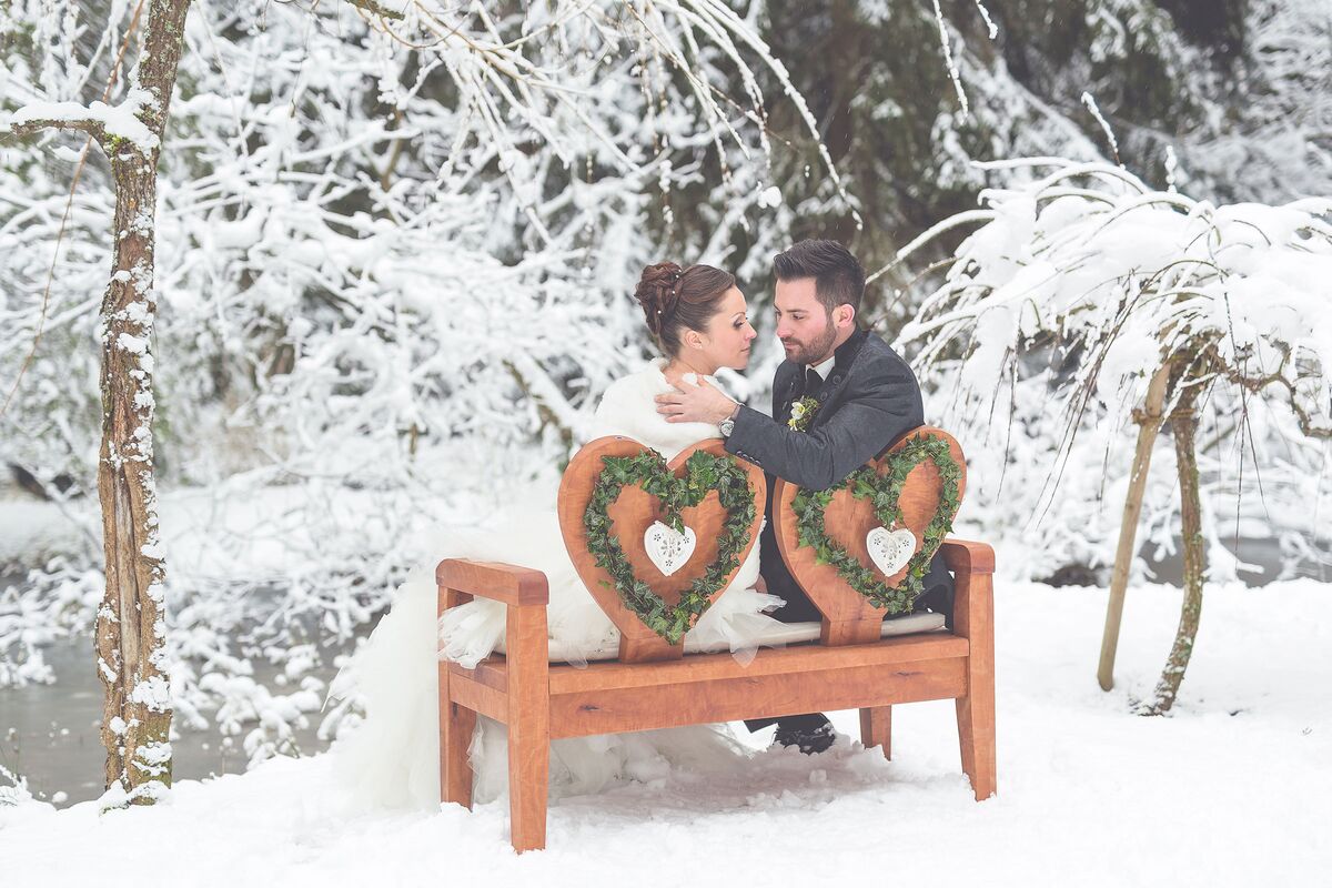 Winterhochzeit auf der Bank im Hotelpark mit Paar