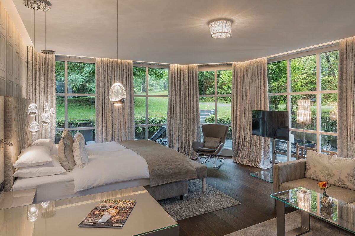 Luxurious Adler Suite with large panoramic windows overlooking the hotel park