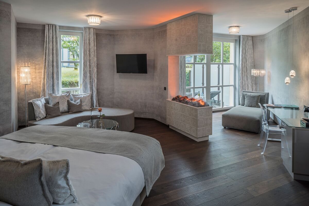 Spacious Residence Junior Suite with a double bed, seating area, fireplace and desk at Parkhotel Adler in Hinterzarten.