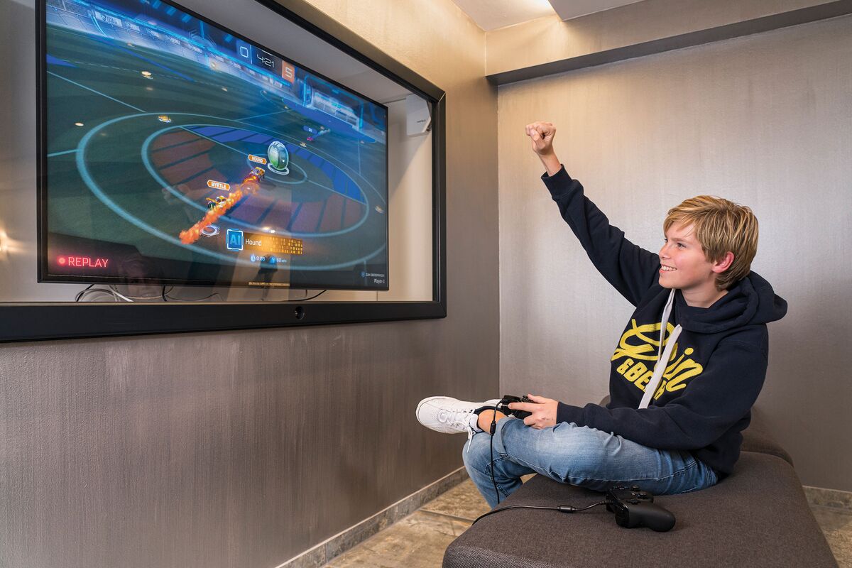 Teenager Lounge mit Spielekonsole und jubeldem Jungen